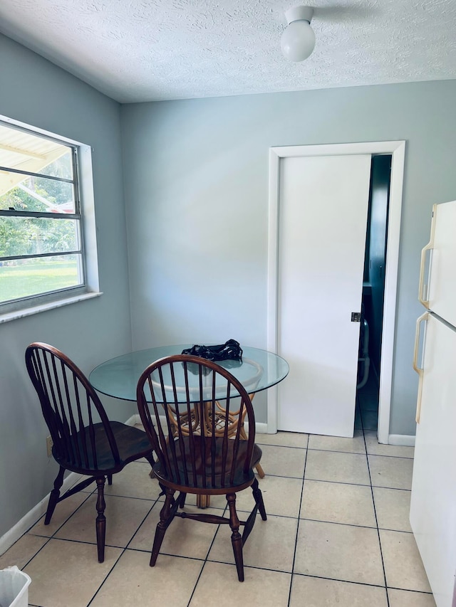 dining space with light tile floors and a textured ceiling