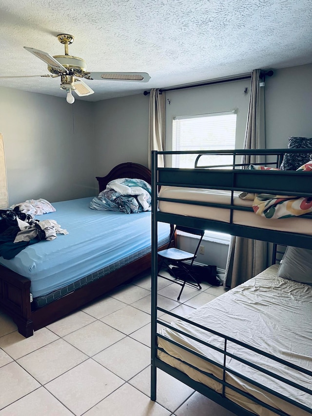 tiled bedroom featuring ceiling fan and a textured ceiling