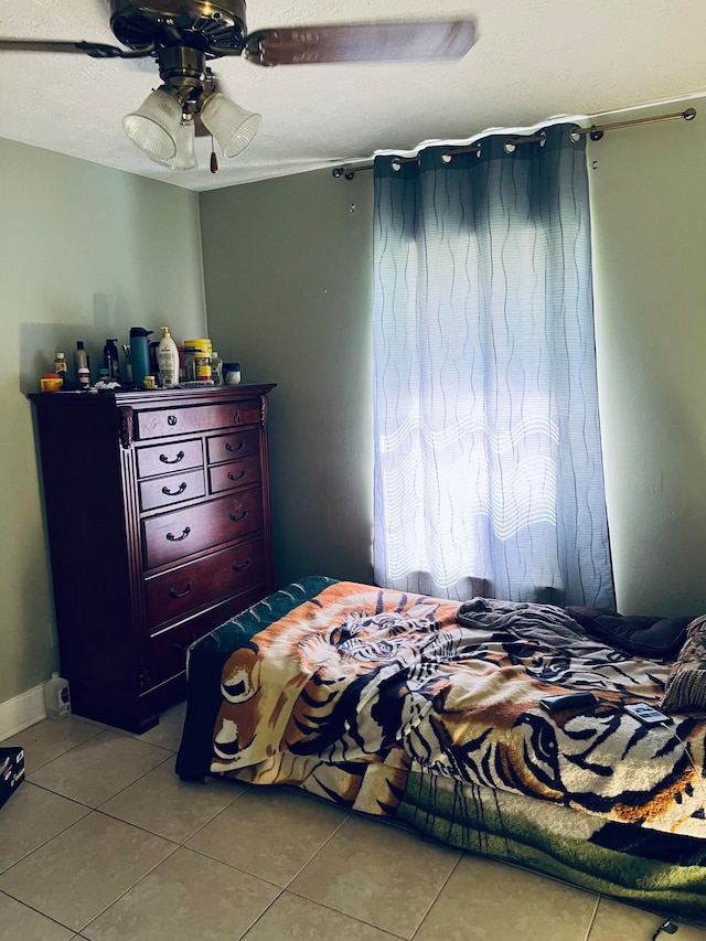 bedroom featuring light tile floors and ceiling fan