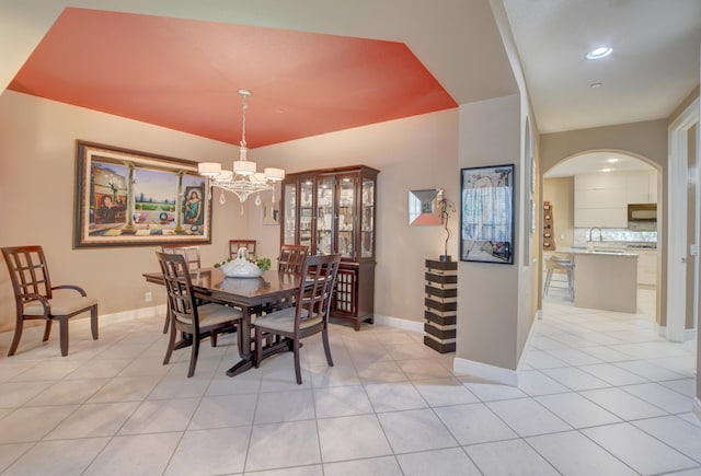 tiled dining space featuring sink and an inviting chandelier