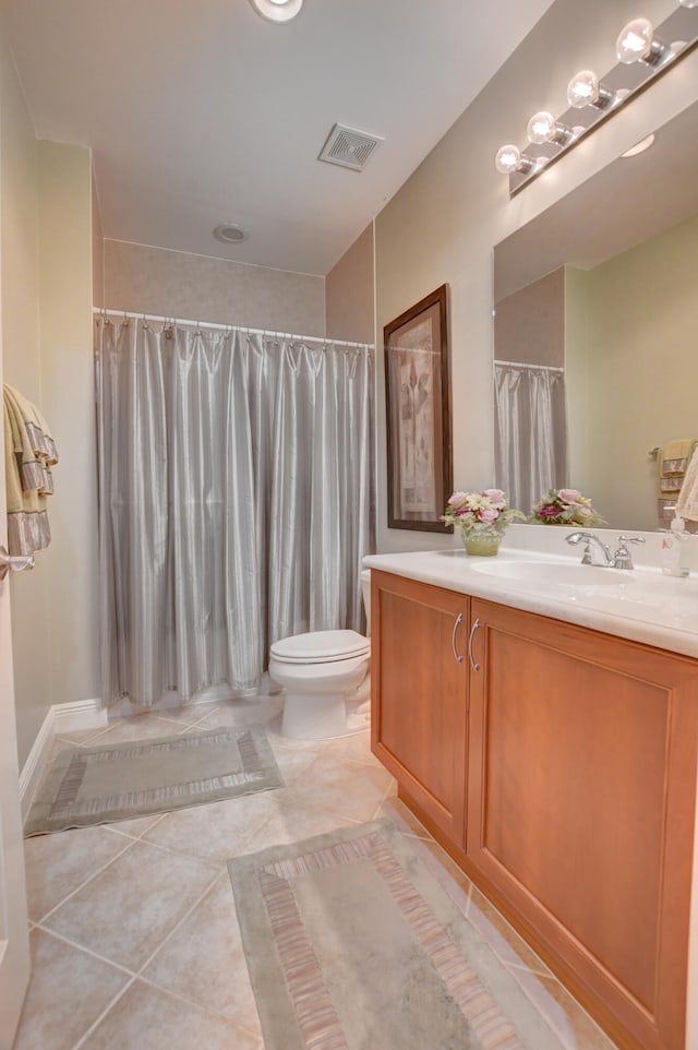 bathroom with tile floors, toilet, and vanity