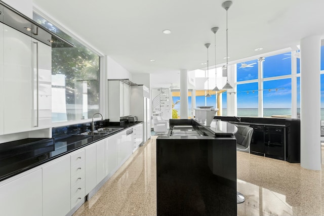 kitchen with white cabinetry, sink, a water view, and pendant lighting