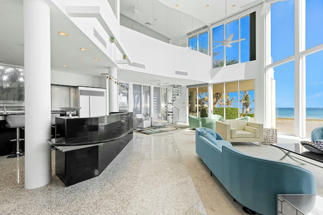 living room with a towering ceiling and a water view