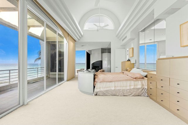 carpeted bedroom featuring access to exterior, a water view, and high vaulted ceiling