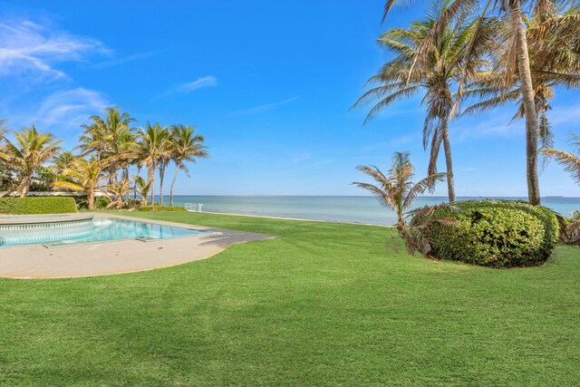 view of swimming pool featuring a yard and a water view