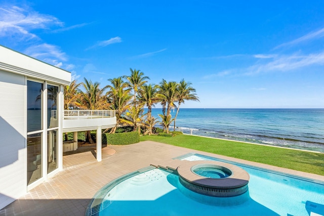 view of swimming pool featuring an in ground hot tub, a patio, a water view, and a beach view