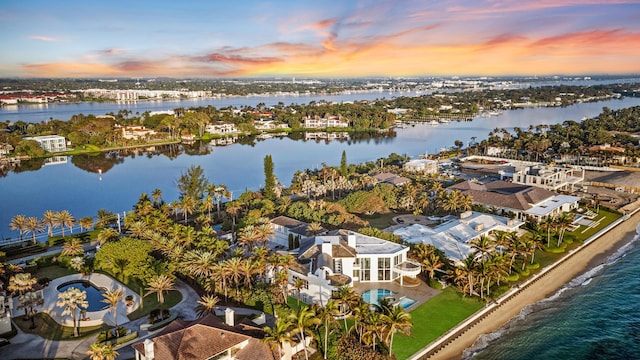 aerial view at dusk featuring a water view