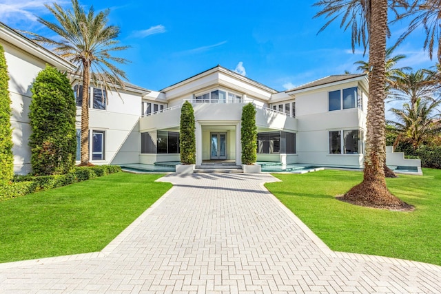 view of front of house featuring a balcony and a front yard