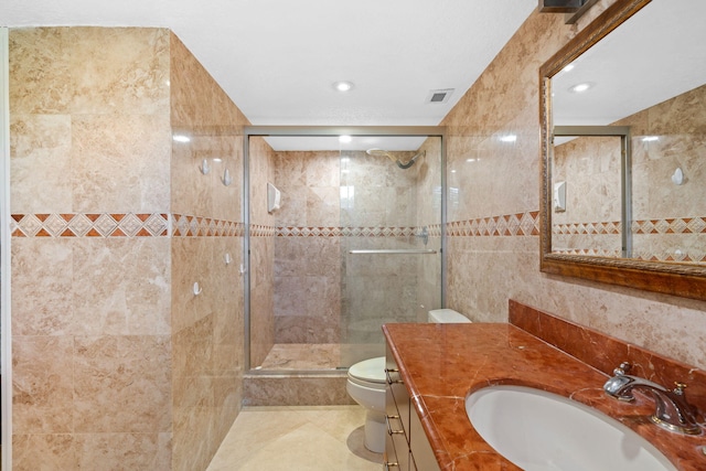 bathroom featuring an enclosed shower, vanity, tile walls, tile flooring, and toilet