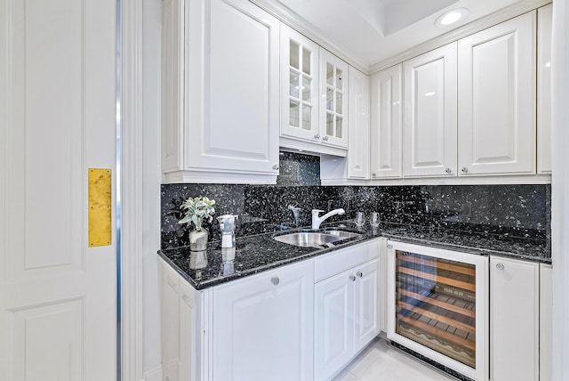 kitchen featuring sink, white cabinets, and wine cooler