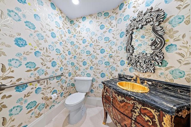 bathroom featuring toilet, vanity, and tile flooring