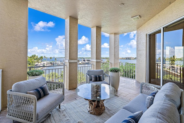 balcony with an outdoor hangout area and a water view