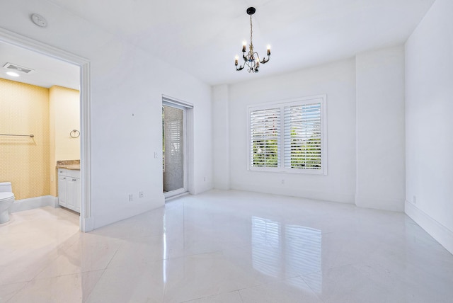 tiled empty room featuring a chandelier