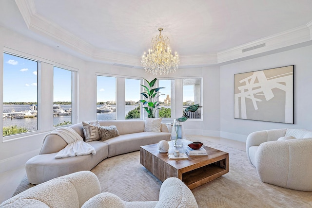 living room with an inviting chandelier, crown molding, a healthy amount of sunlight, and a water view