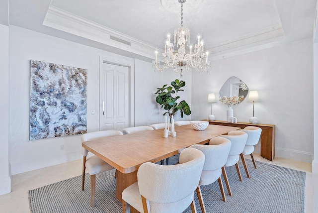 dining space featuring a tray ceiling, ornamental molding, and a chandelier