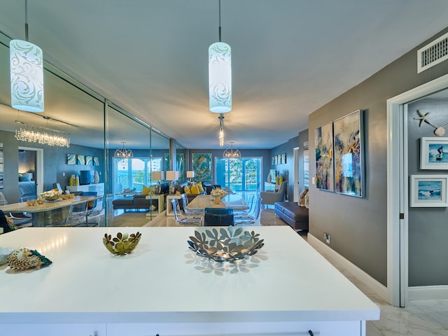 kitchen with pendant lighting, light tile floors, and a notable chandelier