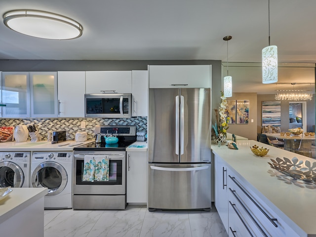 kitchen featuring appliances with stainless steel finishes, hanging light fixtures, independent washer and dryer, white cabinetry, and light tile floors