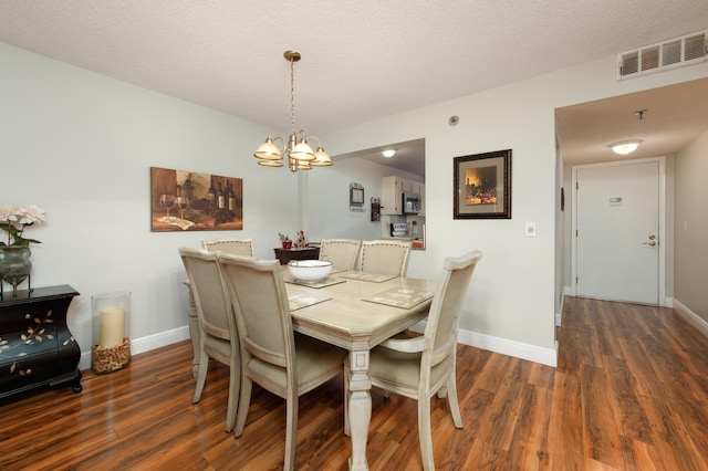 dining room featuring visible vents, baseboards, and wood finished floors