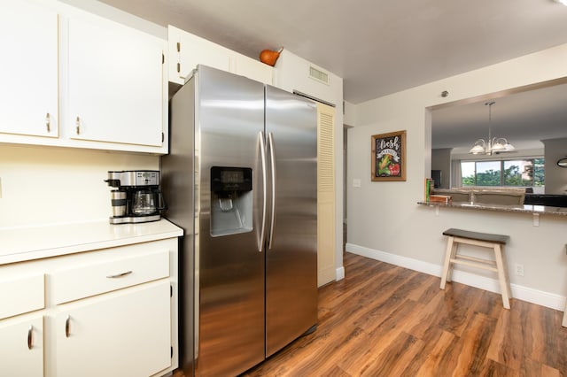 kitchen featuring wood finished floors, stainless steel refrigerator with ice dispenser, and white cabinetry