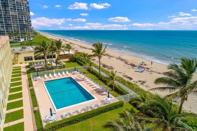 view of swimming pool featuring a view of the beach, a patio area, and a water view