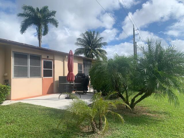 back of house featuring a lawn and a patio