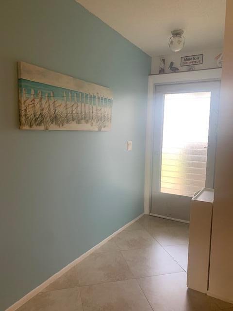 empty room featuring plenty of natural light and light tile patterned floors