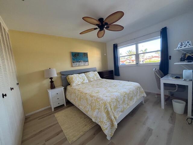 bedroom with ceiling fan, a closet, and light hardwood / wood-style floors