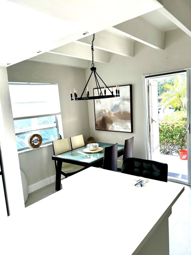 interior space with beam ceiling and a chandelier