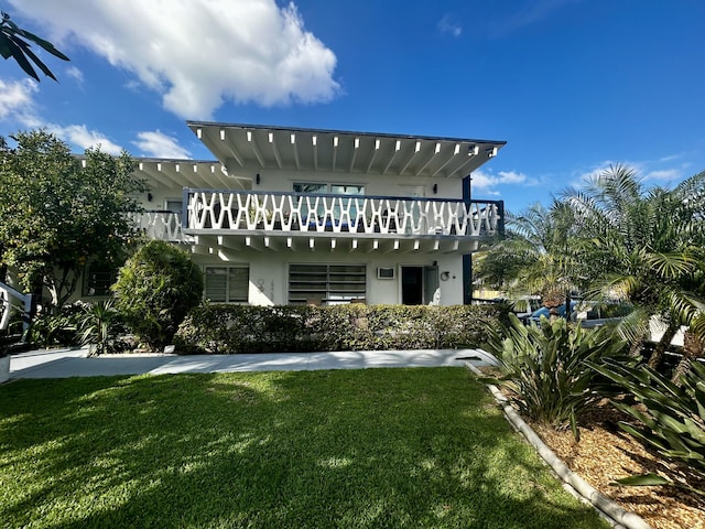 back of house with a yard and stucco siding