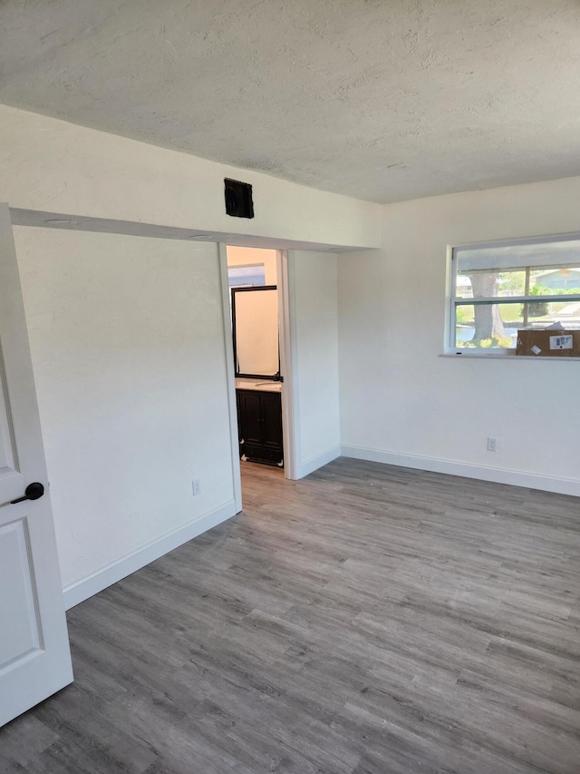 spare room with wood-type flooring and a textured ceiling