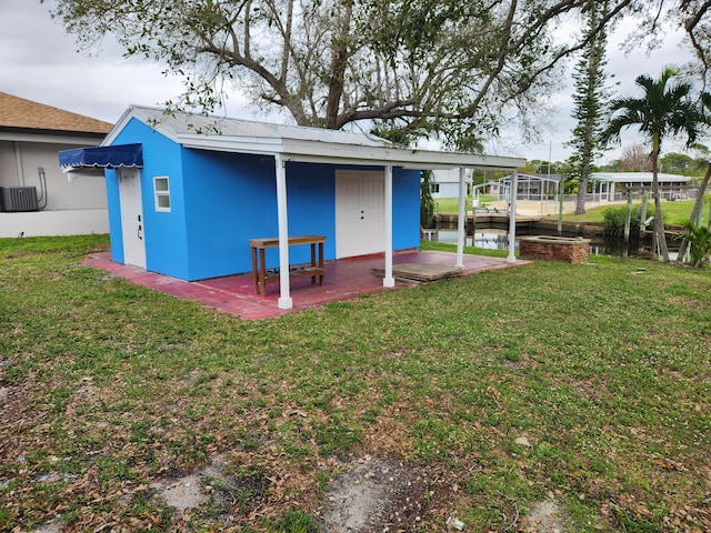 exterior space with central AC unit and a lawn