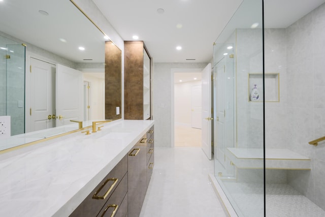 bathroom with tile walls, vanity, a shower with door, and tile flooring