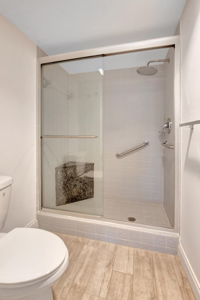 bathroom with toilet and an enclosed shower