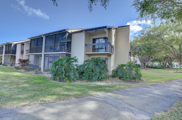 exterior space with a lawn and a balcony