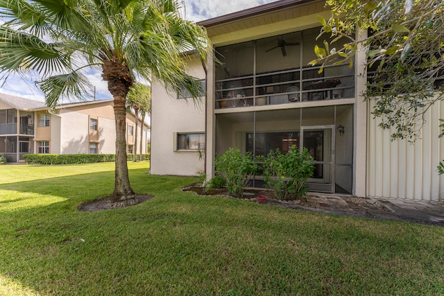 rear view of house featuring a balcony and a yard