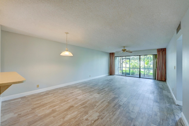 spare room featuring a textured ceiling, ceiling fan, and light hardwood / wood-style flooring