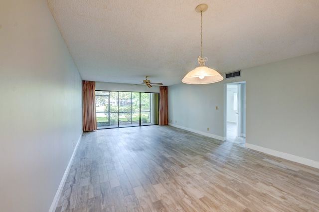 unfurnished room featuring a textured ceiling, ceiling fan, and light hardwood / wood-style flooring