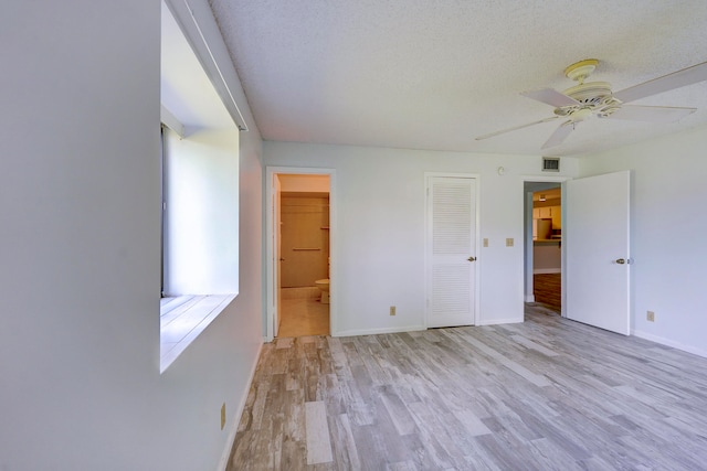 spare room with a textured ceiling, ceiling fan, and light hardwood / wood-style flooring