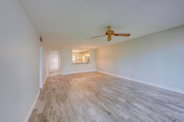 unfurnished living room with a textured ceiling, light hardwood / wood-style floors, and ceiling fan