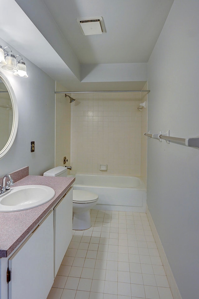 full bathroom featuring tile floors, tiled shower / bath combo, toilet, and vanity