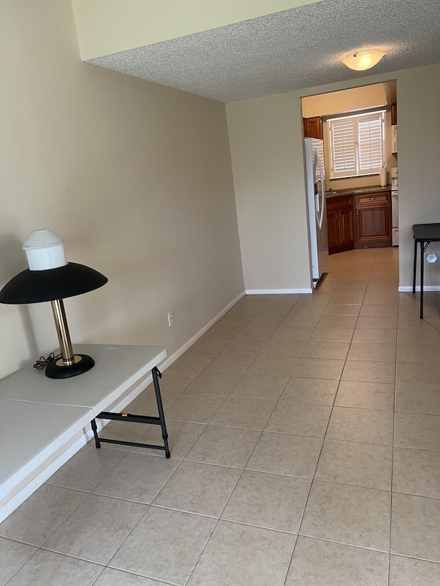 interior space with a textured ceiling and tile floors