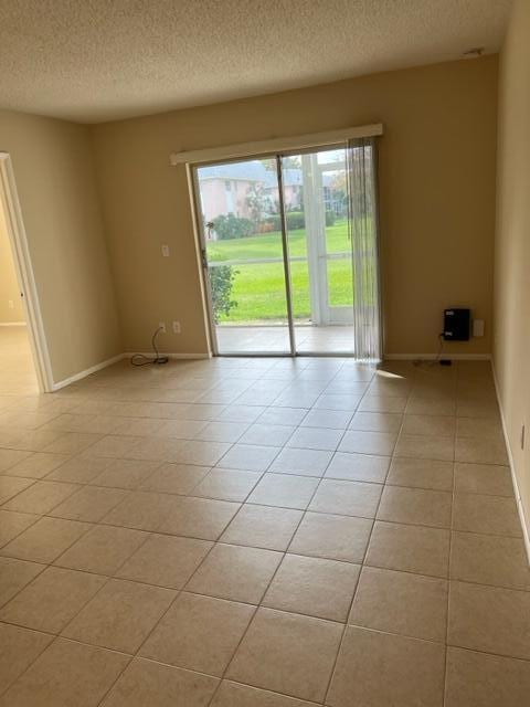 empty room featuring light tile floors and a textured ceiling