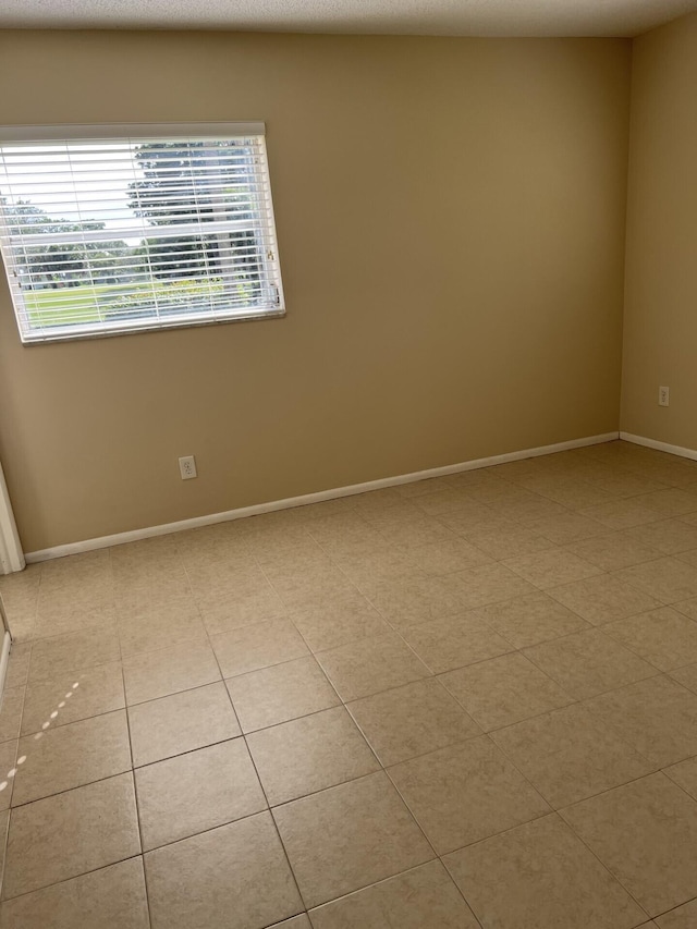 spare room with plenty of natural light and light tile floors