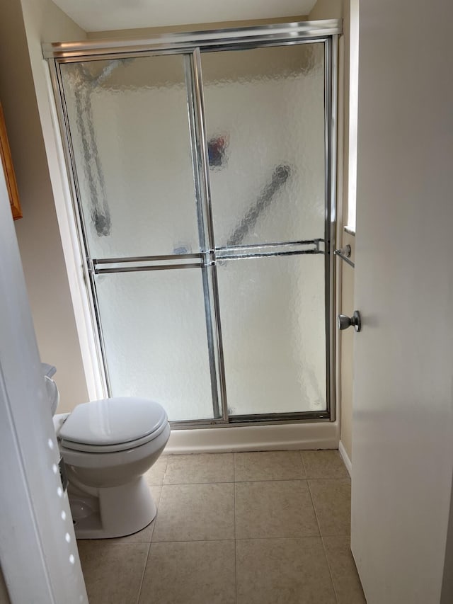 bathroom featuring walk in shower, toilet, and tile floors