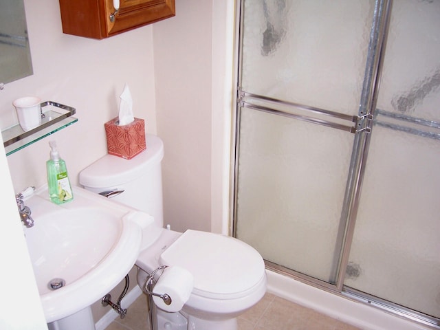 bathroom featuring sink, tile floors, a shower with shower door, and toilet