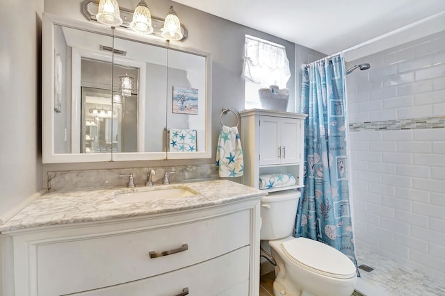 bathroom with a shower with shower curtain, vanity with extensive cabinet space, and toilet