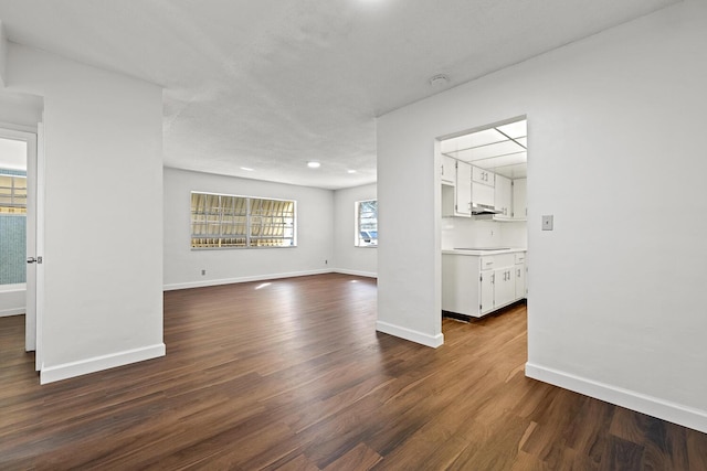 unfurnished living room featuring dark wood-type flooring