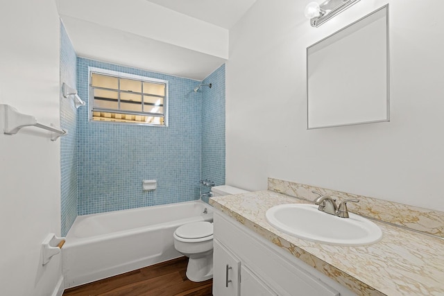 full bathroom with toilet, tiled shower / bath, wood-type flooring, and vanity