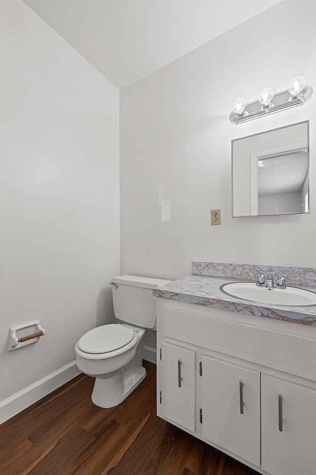 bathroom featuring toilet, hardwood / wood-style flooring, and vanity