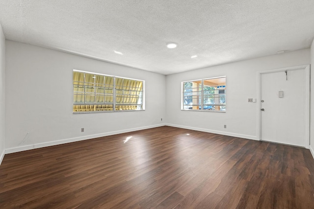 unfurnished room featuring a textured ceiling and dark wood-type flooring